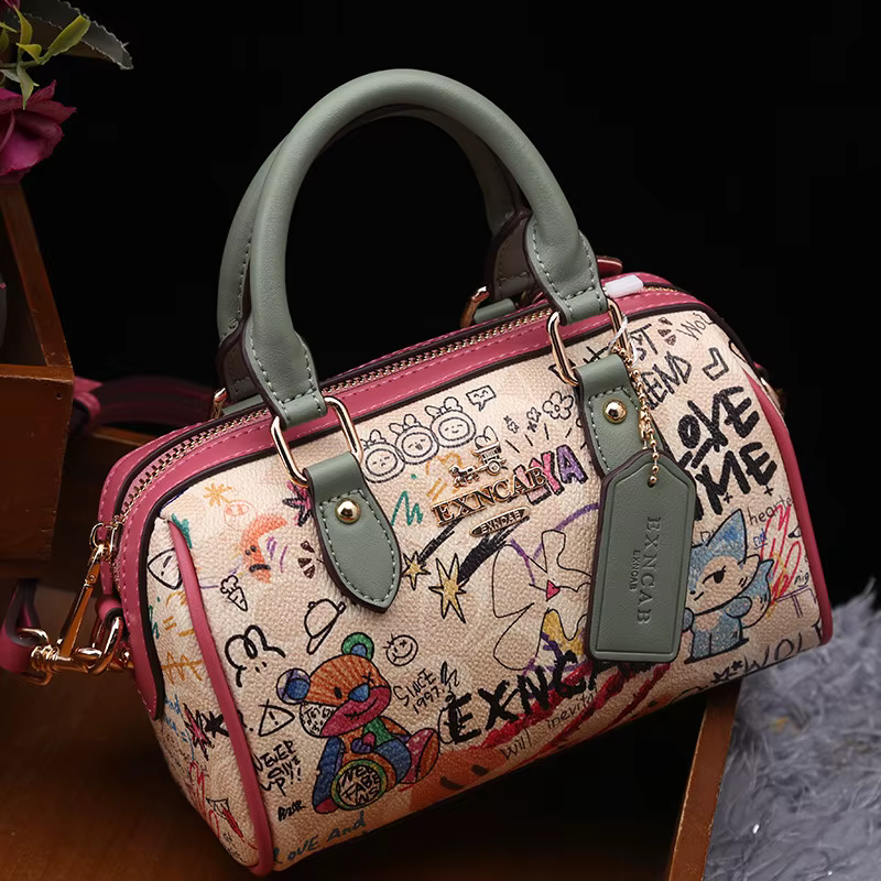 Sac Boston de luxe et vintage à porter à la main avec motifs graffiti de dessins animés tendance et cuir premium, sac bandoulière pour femme nouvelle tendance 2026