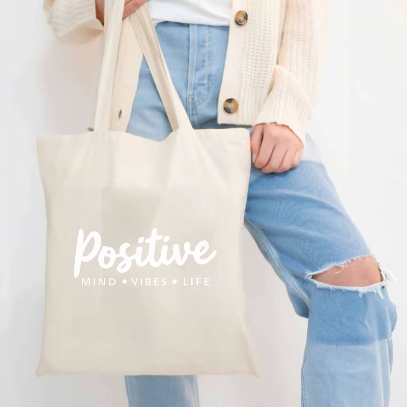 Sac fourre-tout en toile de couleur crème avec slogan vivant mindset positif imprimé sur le devant