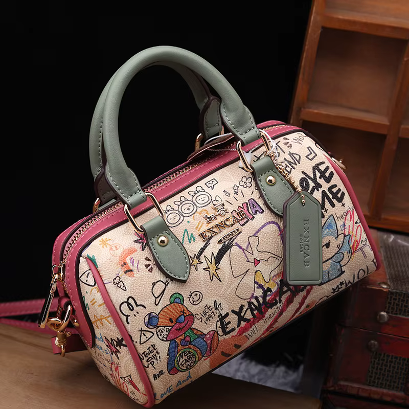 Sac Boston de luxe et vintage à porter à la main avec motifs graffiti de dessins animés tendance et cuir premium, sac bandoulière pour femme nouvelle tendance 2026