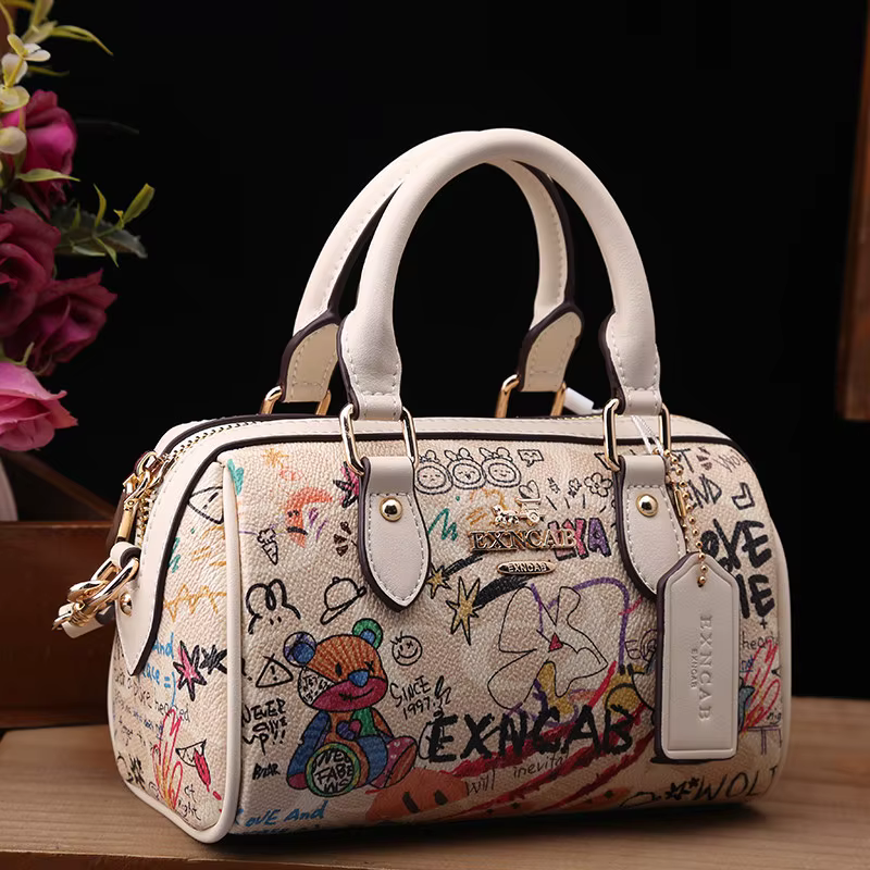 Sac Boston de luxe et vintage à porter à la main avec motifs graffiti de dessins animés tendance et cuir premium, sac bandoulière pour femme nouvelle tendance 2026